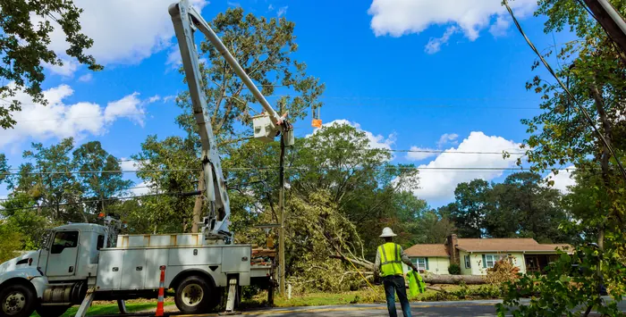 Utility crew and project manager at a bucket truck repairing power lines